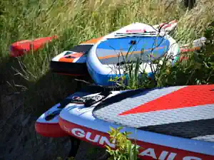 Stand-up paddle boards lying in the dune grass at Schubystrand, ready for free time