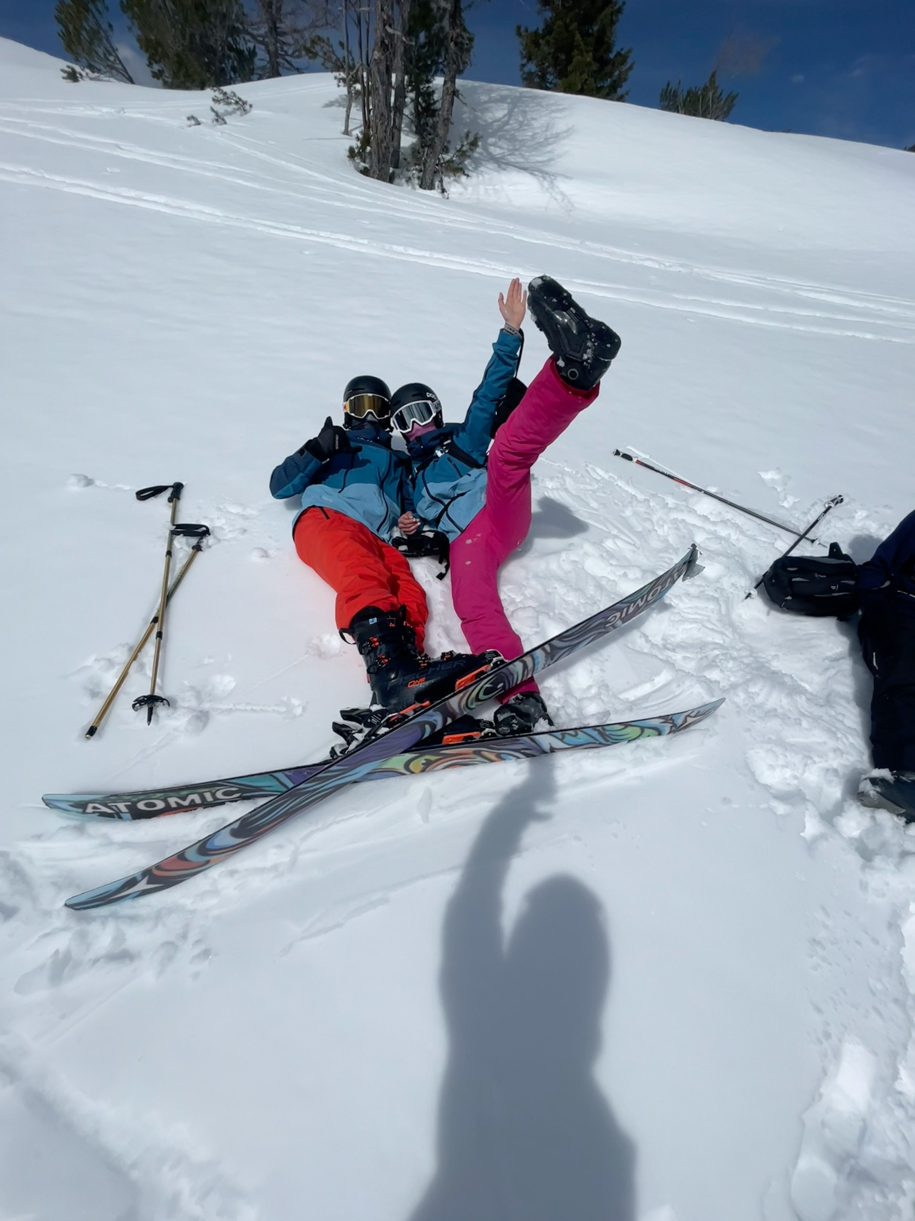 Two guests lying in the snow with their skis
