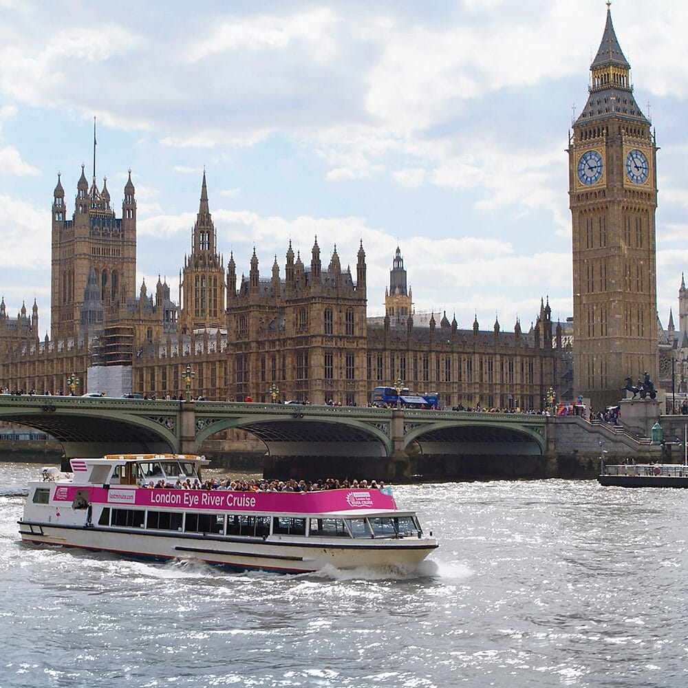 A sightseeing river cruise boat passing the Houses of Parliament and the Elizabeth Tower on the Thames, a London excursion destination