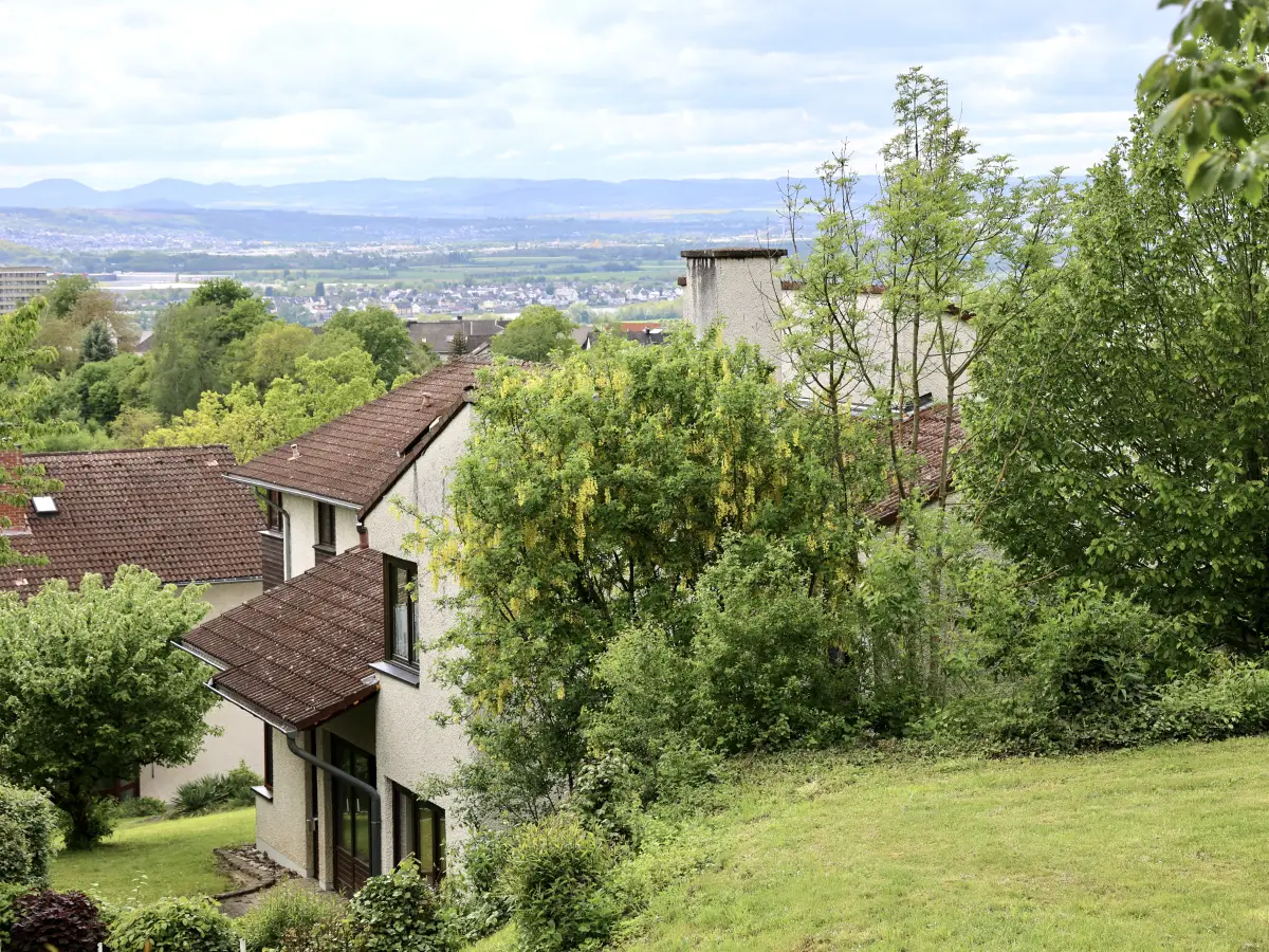 The view from the camp grounds over treetops and village roofs to the hills of the Westerwald beyond