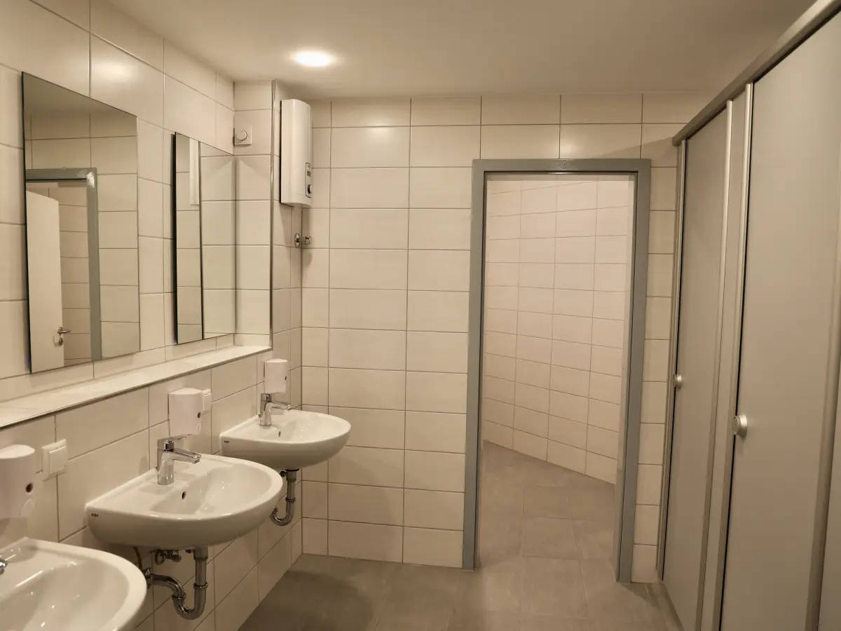 Communal washroom on the accommodation floor with a row of basins, mirrors and toilet cubicles