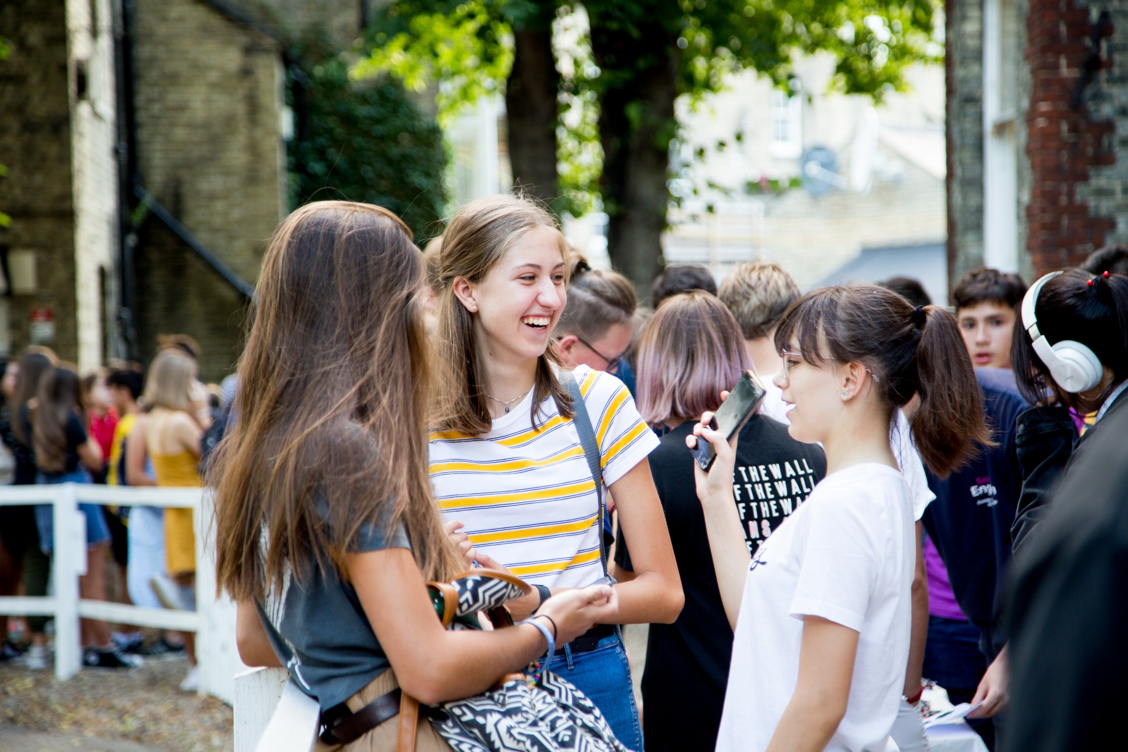 Group of teenage students talking together outside the school building between activities