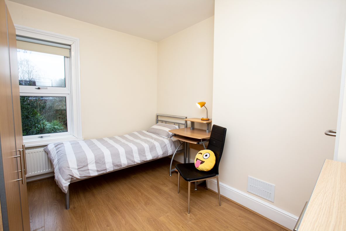 Single bedroom in a Select English hall of residence with a bed, desk and window