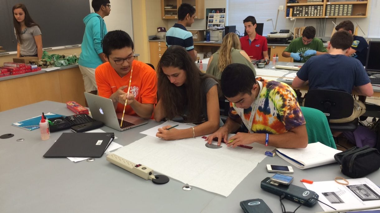 Engineering Innovation students working in teams on spaghetti bridges in a classroom at Hood College