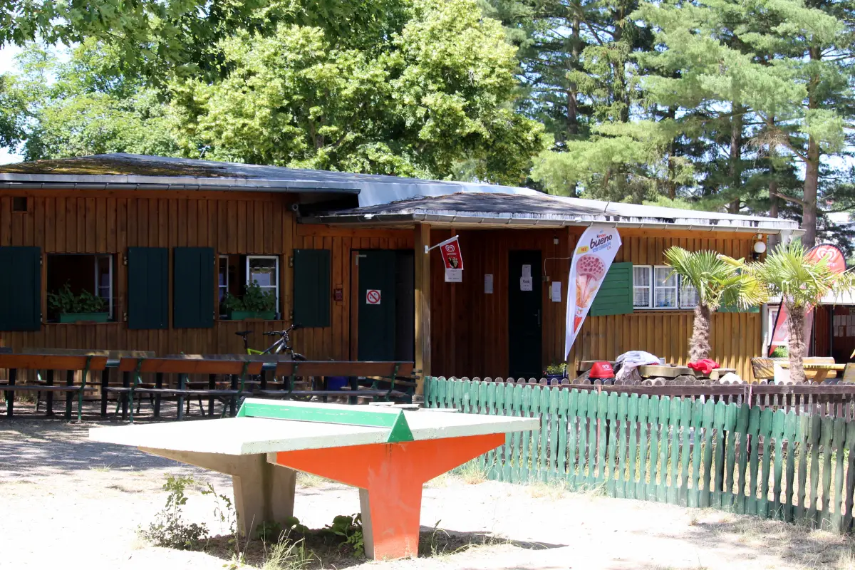 Wooden main building with terrace seating and an outdoor table tennis table