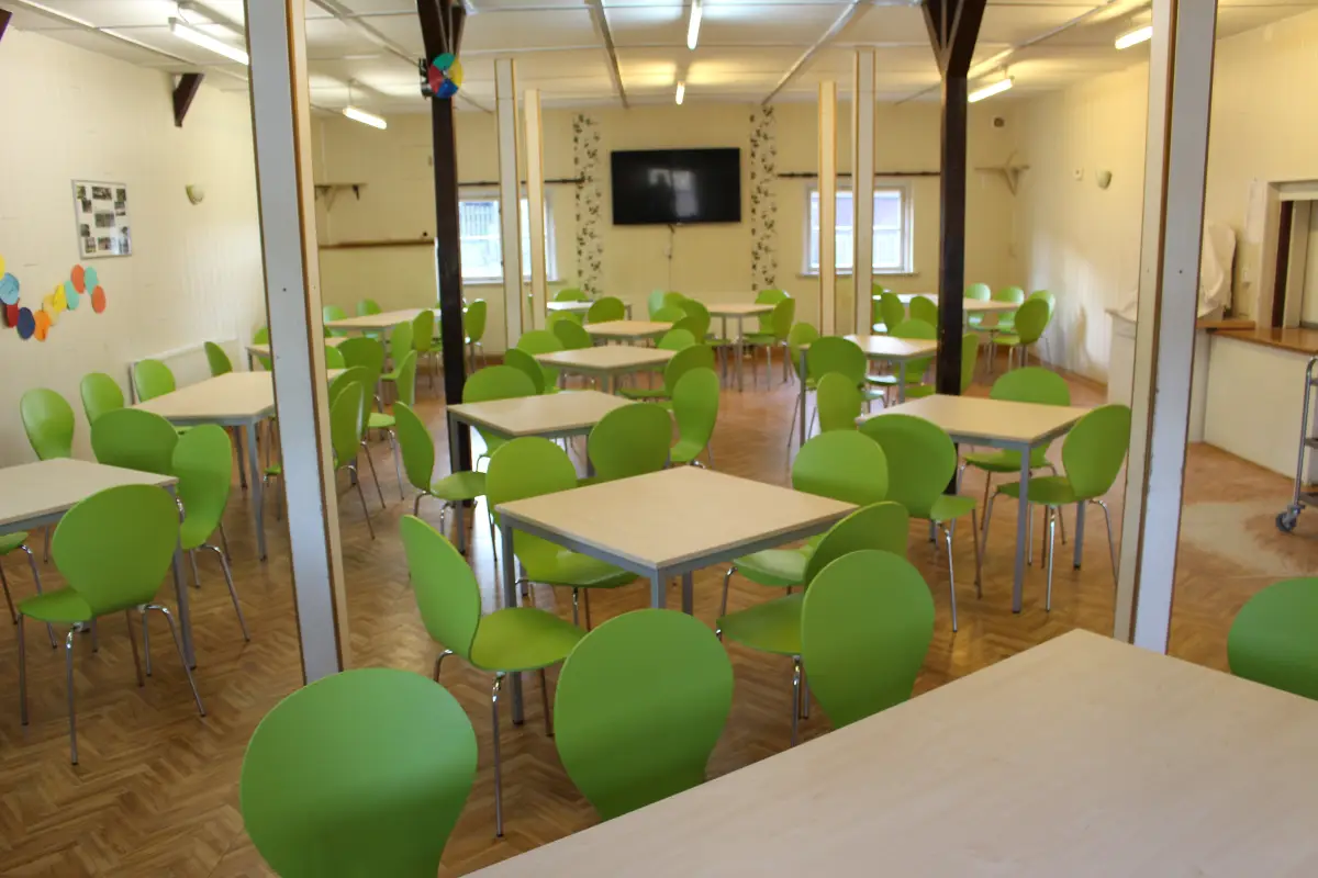 Dining room with green chairs and square tables