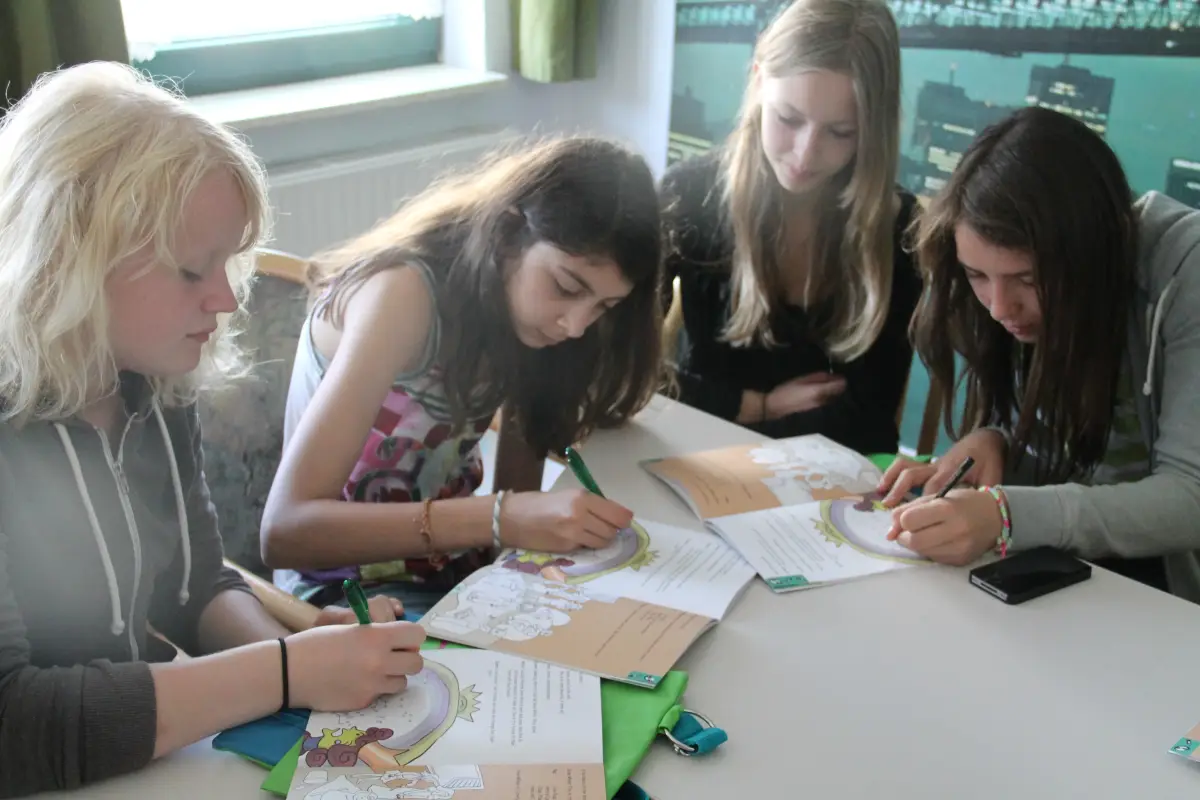 Girls working together on English worksheets at a table