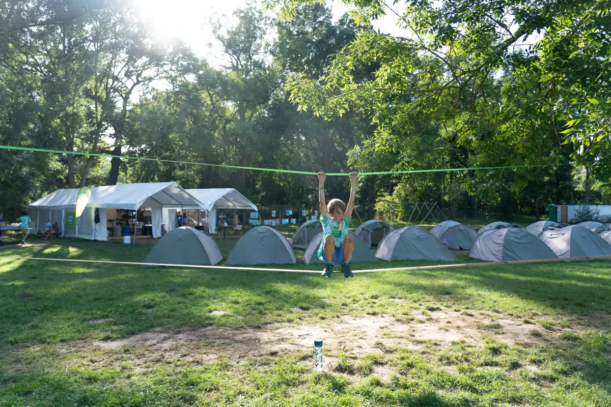 Sleeping tents and a marquee pitched across the campsite with a camper running between them
