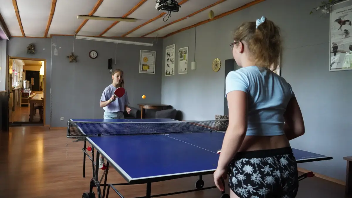 Girl playing table tennis in an indoor games room