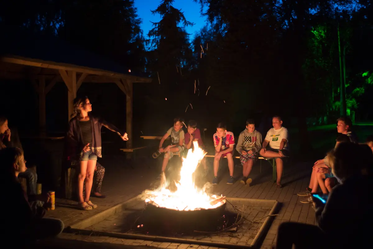 Children sitting around a campfire in the evening