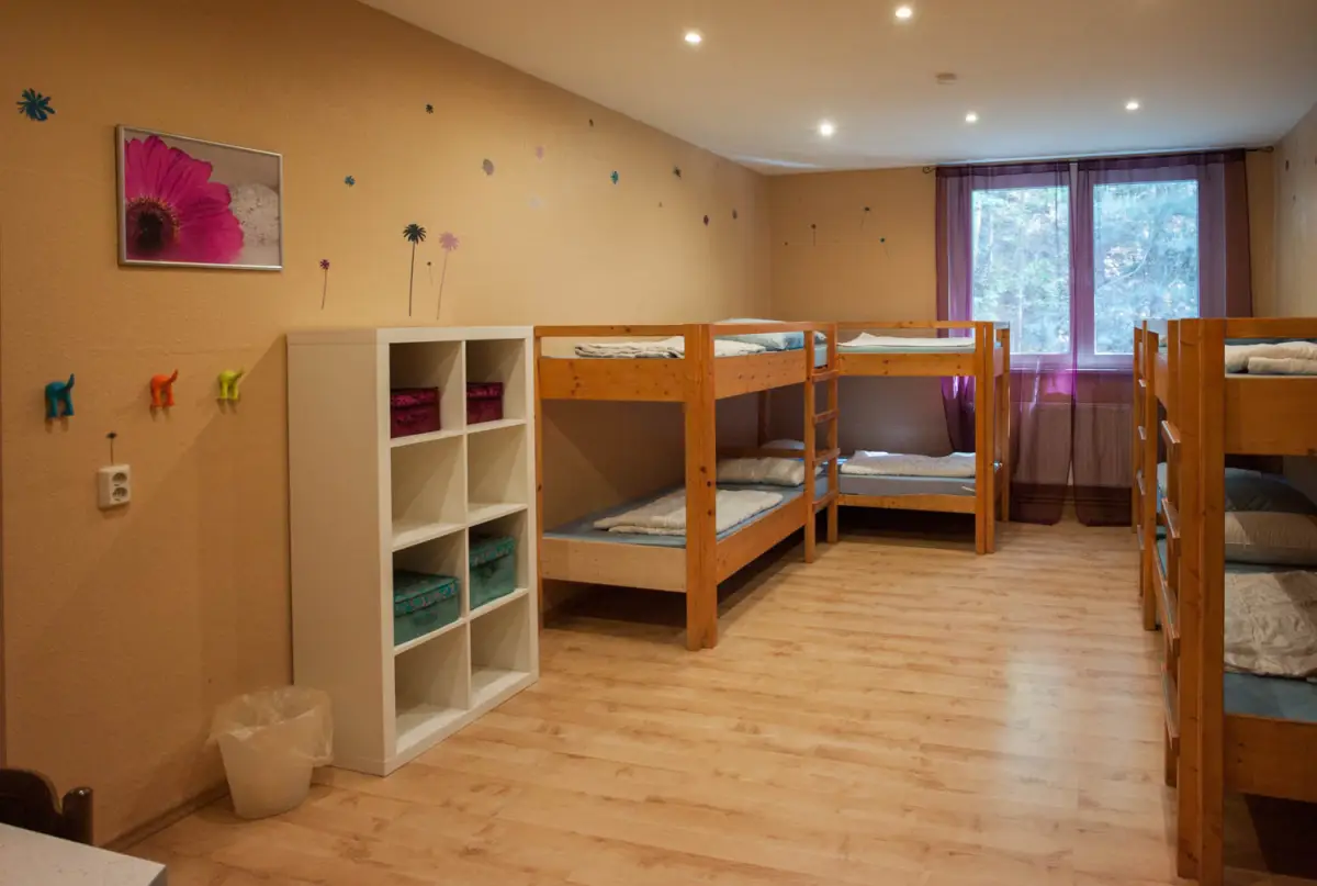 Room with wooden bunk beds and shelves in the dormitory building