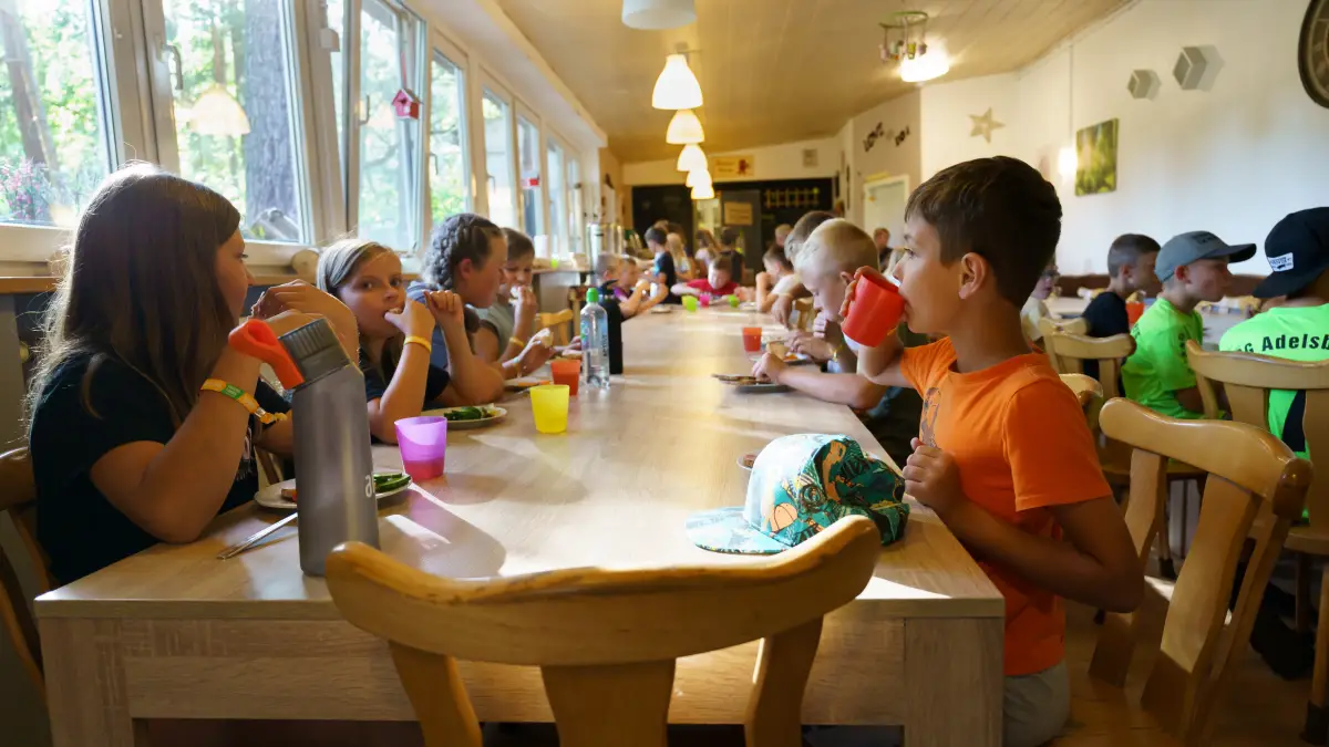 Children eating at wooden tables in the dining room