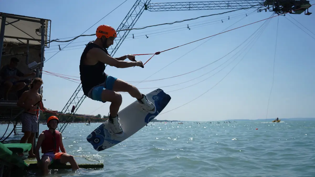 A wakeboarder riding behind the cable tow on Lake Balaton