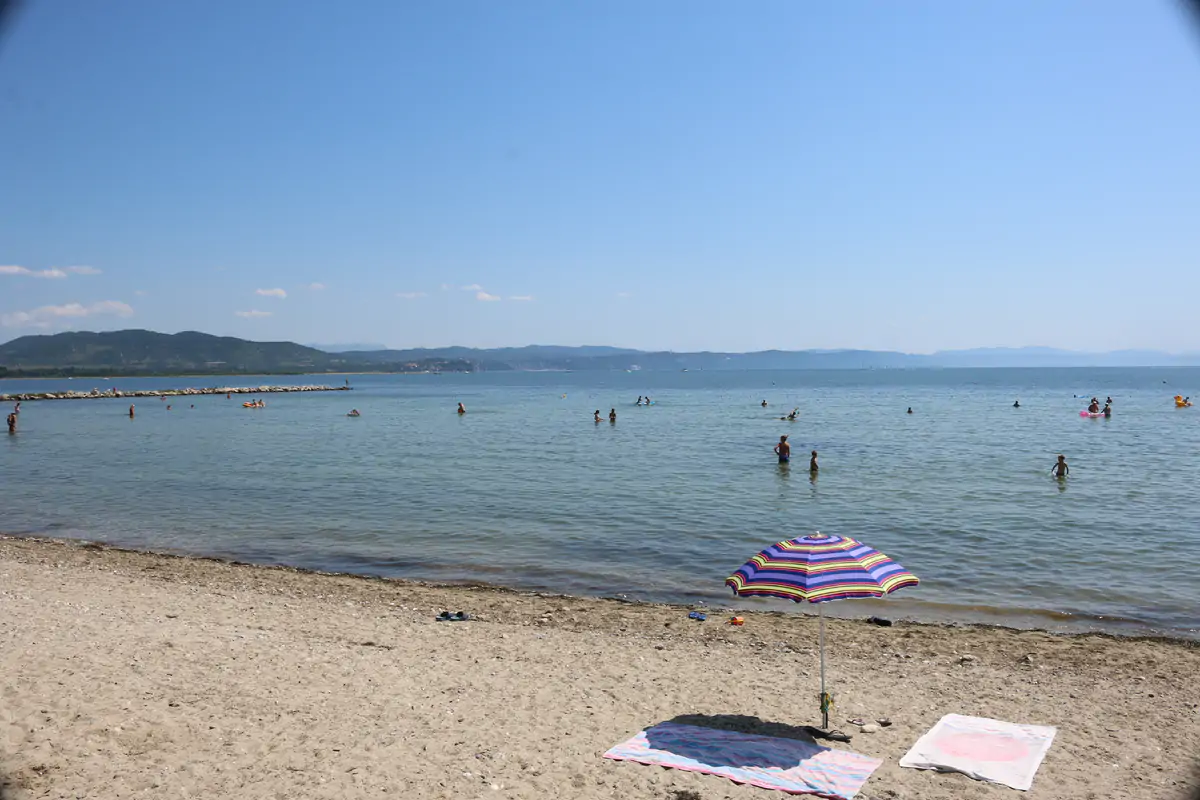 Sandy beach and shallow sea with mountains on the horizon