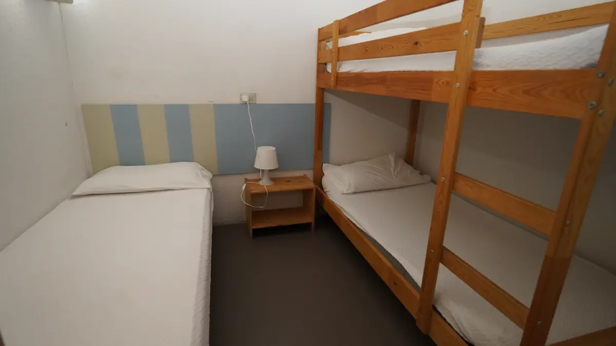Bedroom with a wooden bunk bed and a single bed