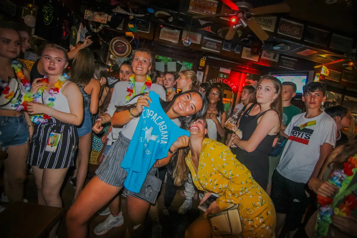 Teenagers crowded together laughing in a beach bar during the evening programme in Rimini