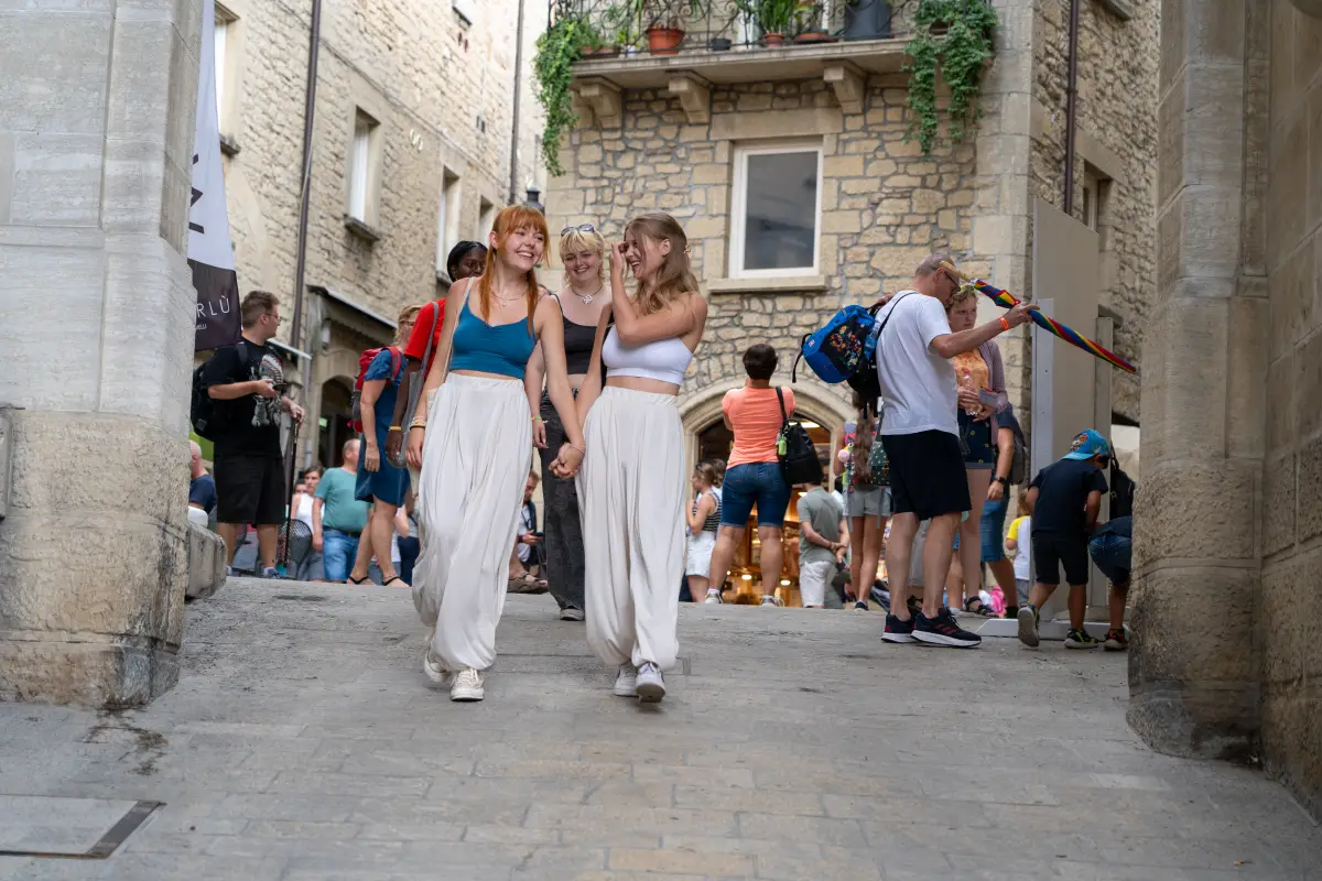 Participants walking through a narrow stone old-town street on a day excursion from Rimini