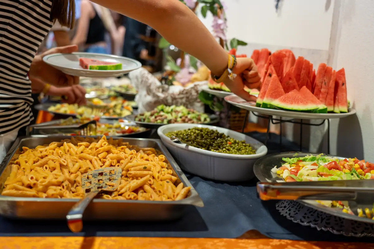 Buffet counter with pasta, salads and sliced watermelon being served at the Jugendtours hotel in Rimini Miramare