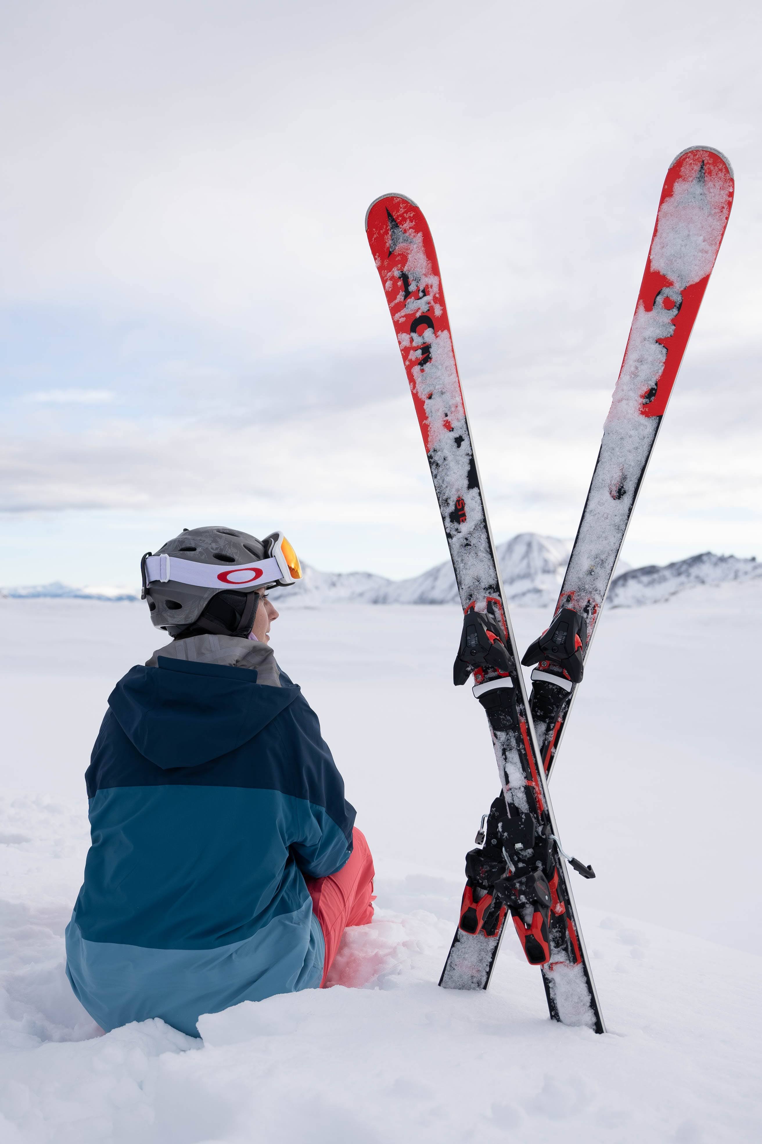 Guest sitting in the snow next to their skis