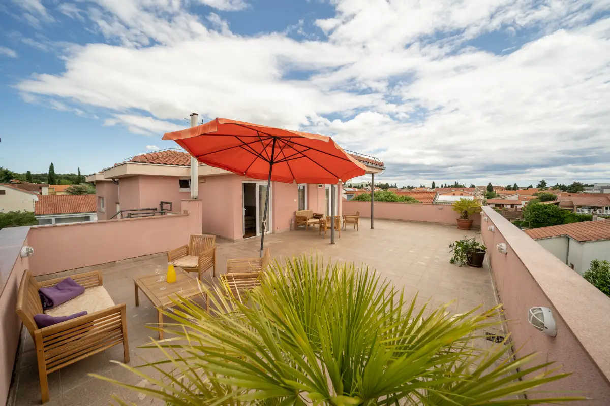 Hotel roof terrace with parasol and seating, looking over the town