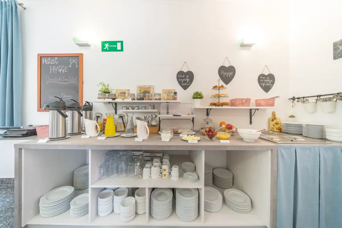 Breakfast buffet station with juices, crockery and bread