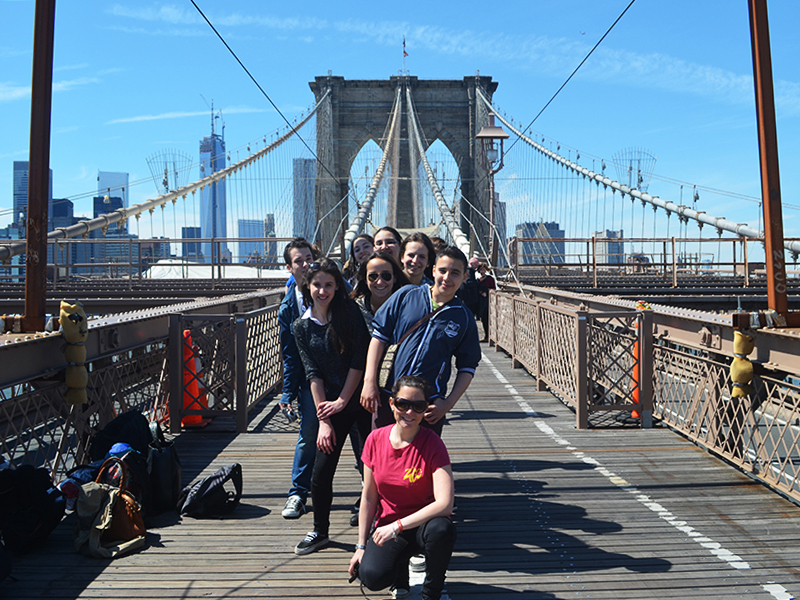 A group of young people walking across Brooklyn Bridge