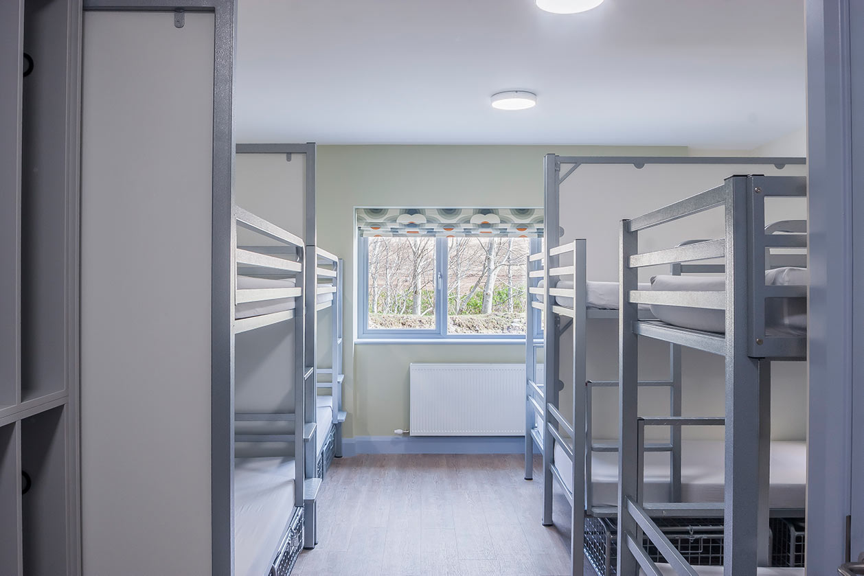 Dormitory room with metal bunk beds and a window at the Wild Atlantic Hostel, Delphi Resort