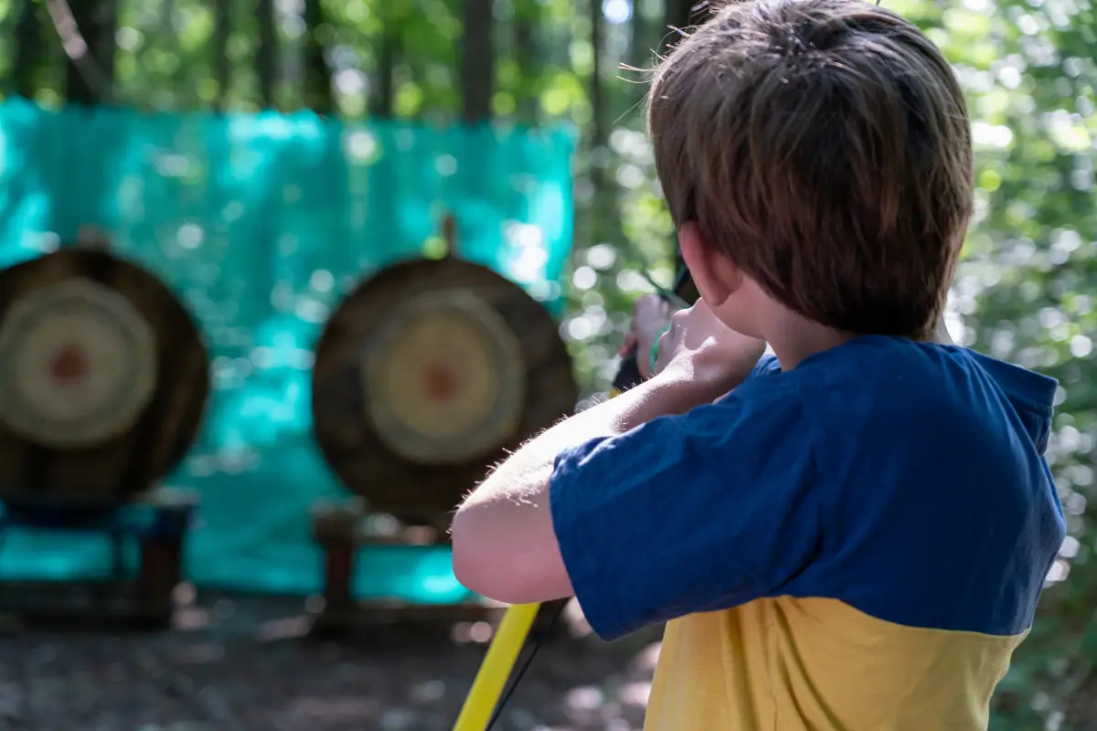 Boy aiming a bow at archery targets