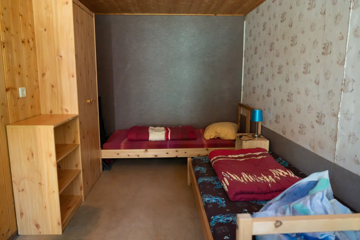 Bungalow room with single beds and a wooden wardrobe