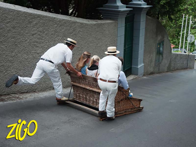 A wicker toboggan and its two carreiros on the basket descent
