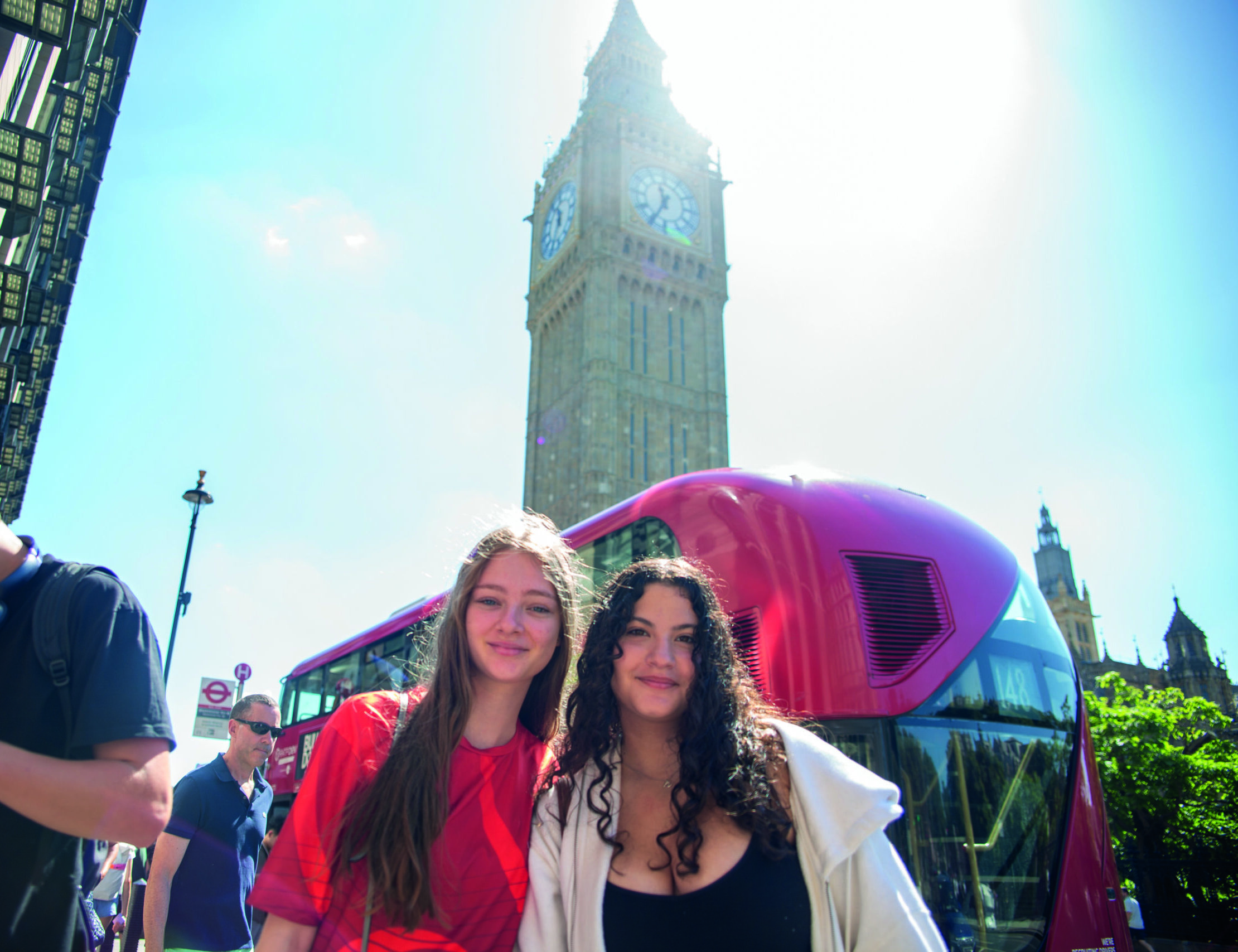 Students sightseeing in London beside Big Ben and a red double-decker bus