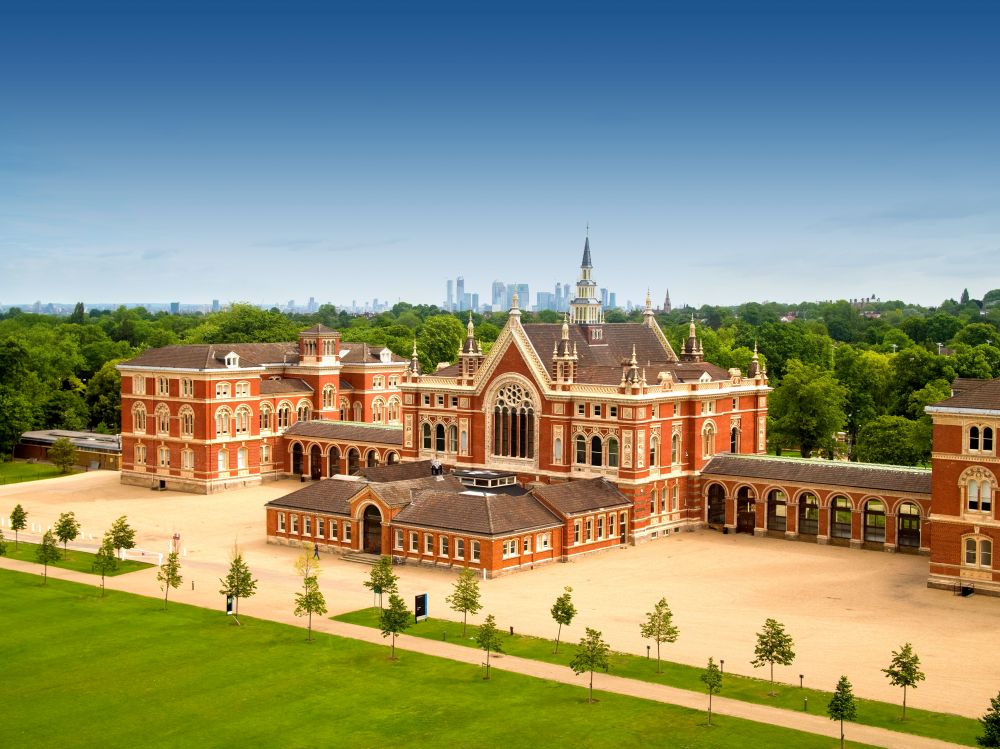 The red brick front of Dulwich College with lawns and the London skyline behind