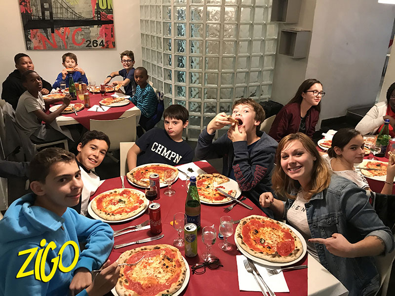 Participants around a restaurant table with Neapolitan pizzas in front of them
