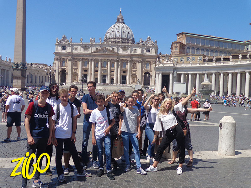 Group of teenagers standing in St Peter’s Square in the Vatican, the dome of the basilica behind them