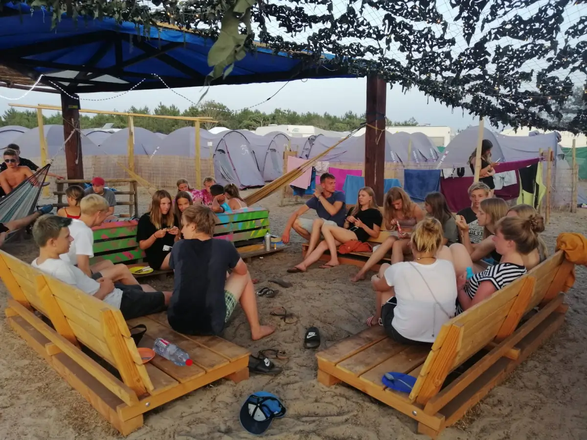 Teenagers relaxing on pallet sofas in the shaded chill-out area
