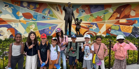 Campers in front of the colourful mural and statue in the park