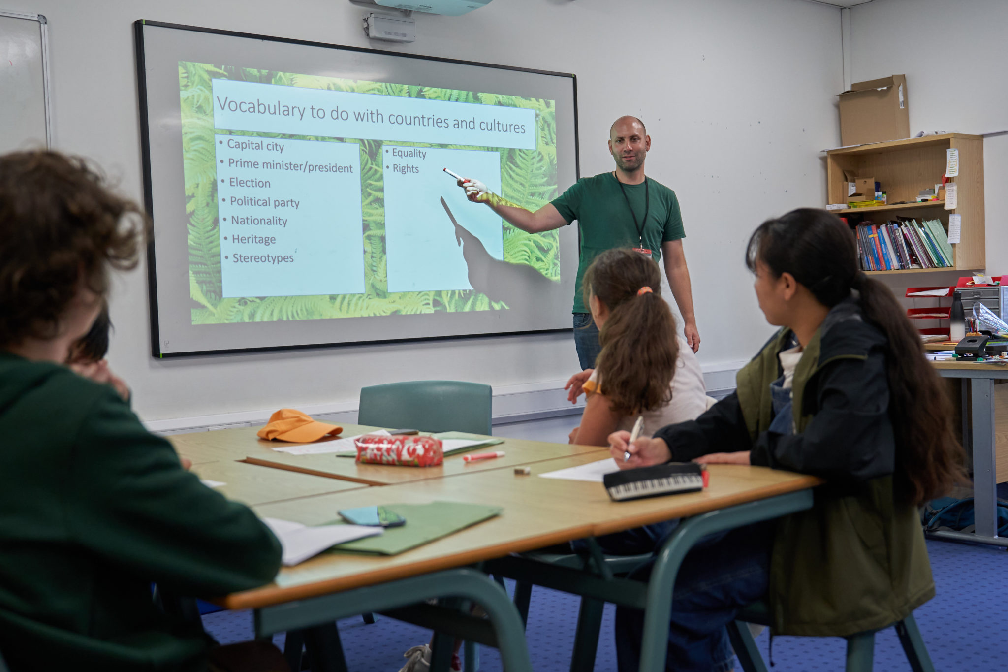 Teacher presenting at a screen to a small English class at Hurst College