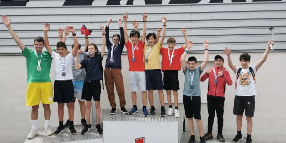Campers with their medals celebrating on the podium at the karting circuit