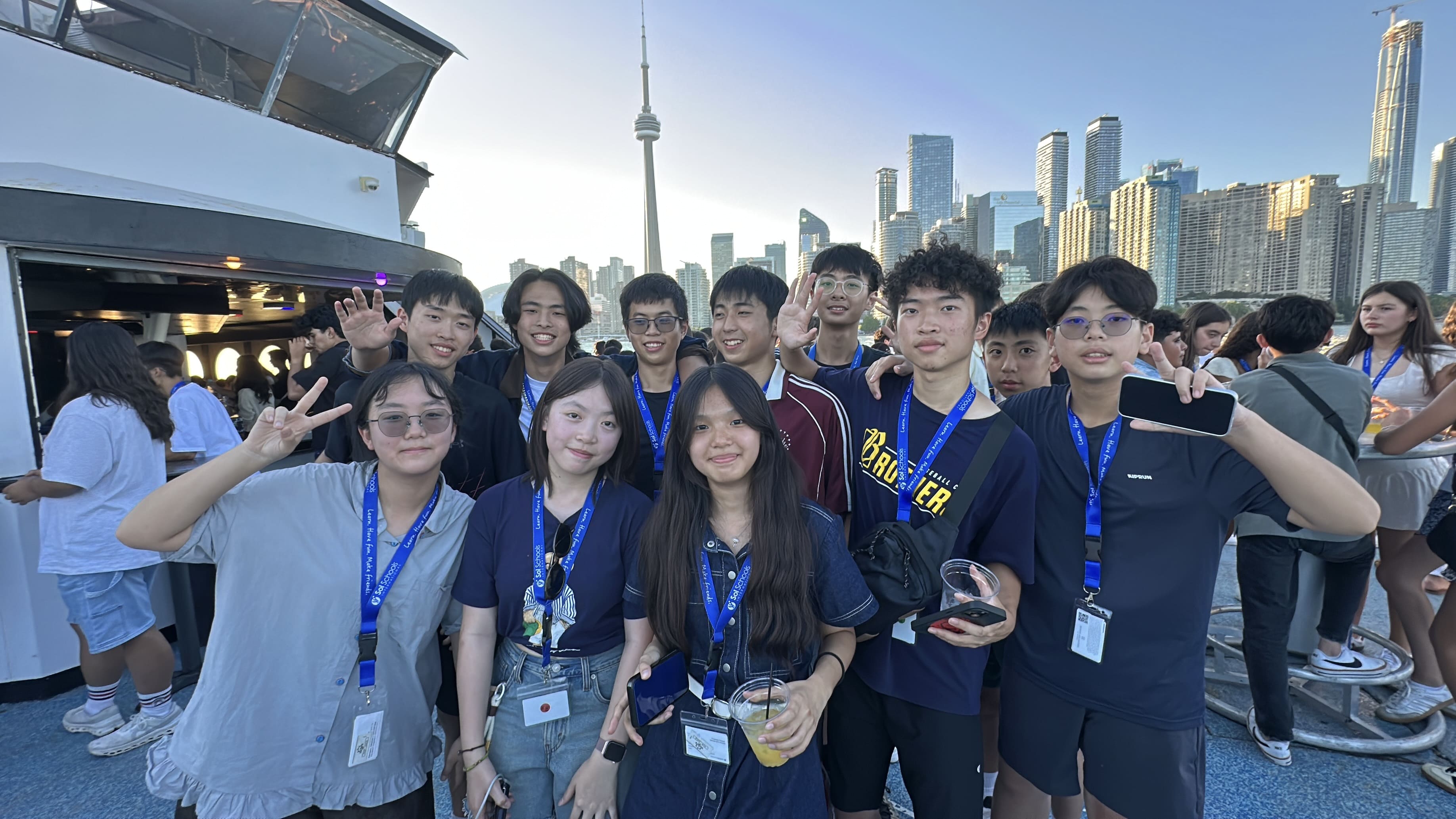 Sol Camps Toronto teens with lanyards on a boat in Toronto harbour with the CN Tower and skyline behind