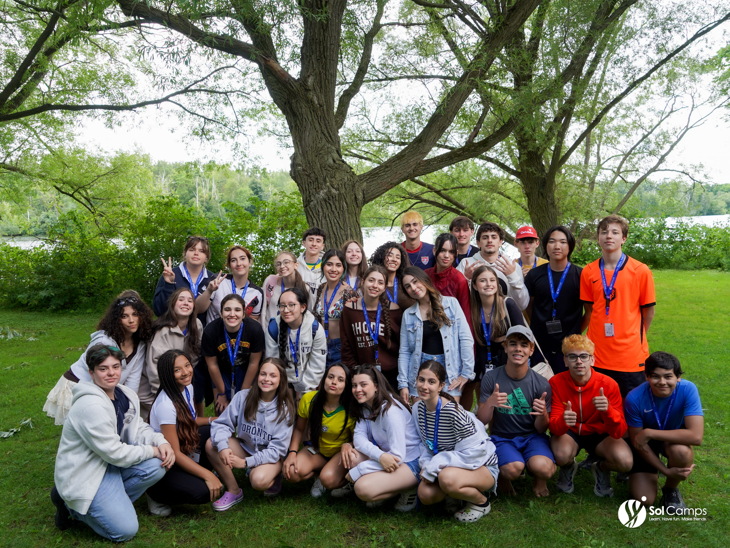 Large group of Sol Camps Toronto campers and staff posing on a lawn under trees