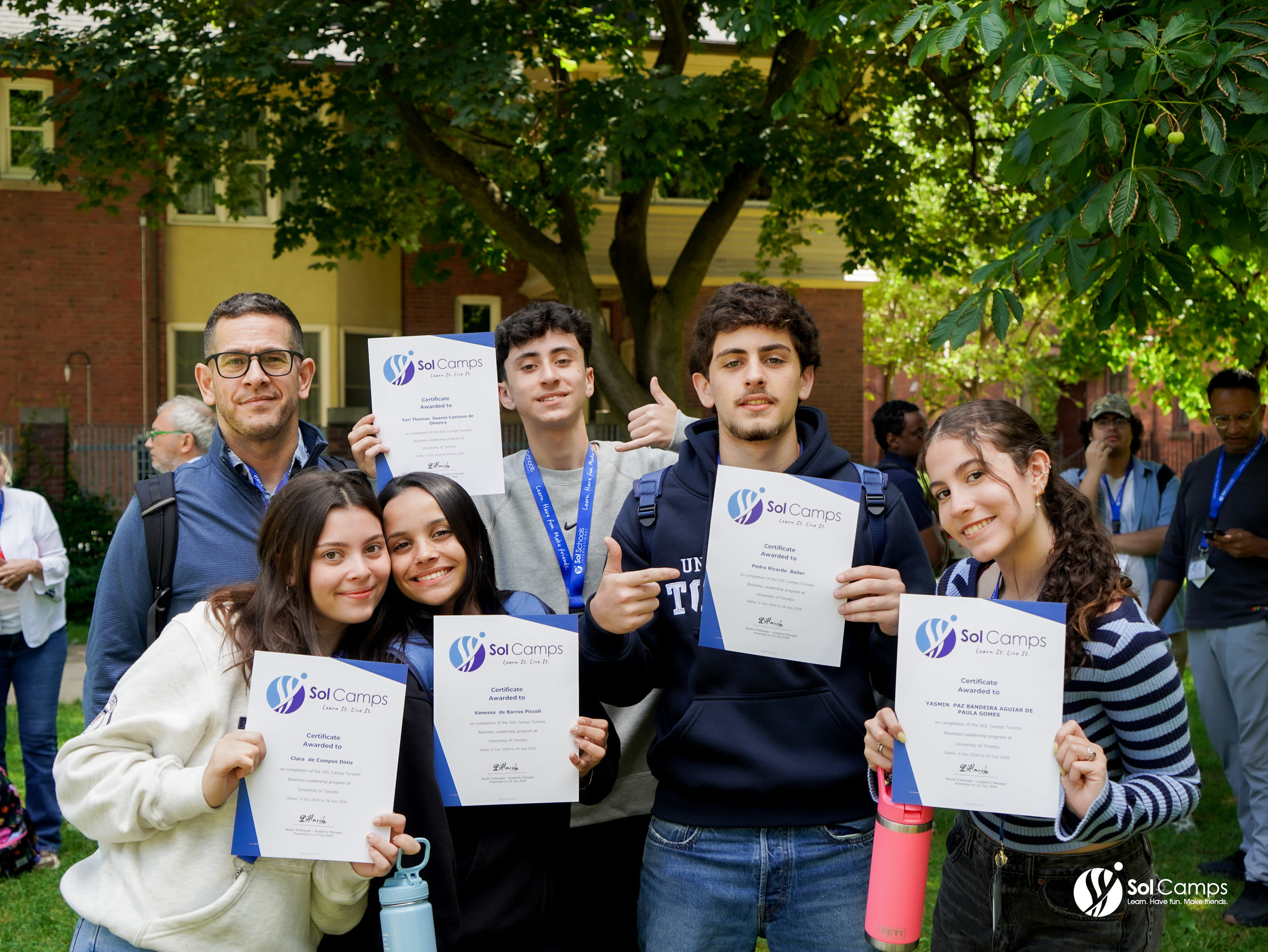 Sol Camps Toronto campers holding their course certificates outside a campus building at the University of Toronto