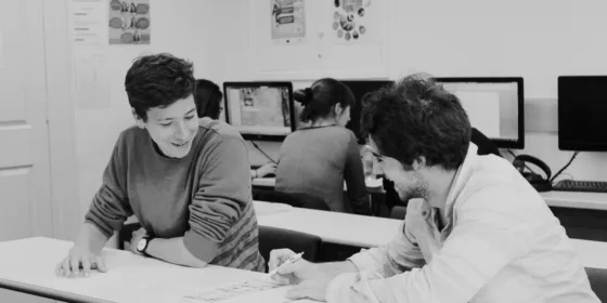 A black and white image of students working together in the self access centre at ELC Chester.