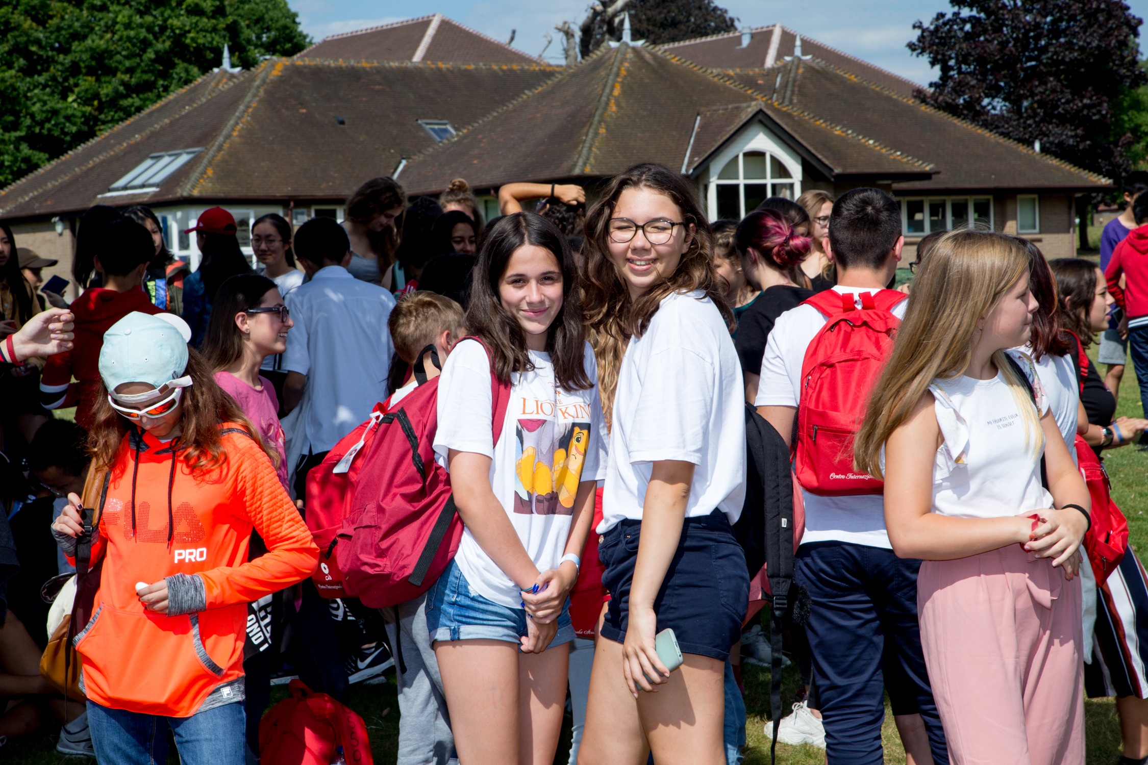 Group of students standing together outside a pavilion building on the school grounds