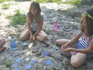 Girls playing cards on the sand in free time at Kindererholungszentrum Am Braunsteich