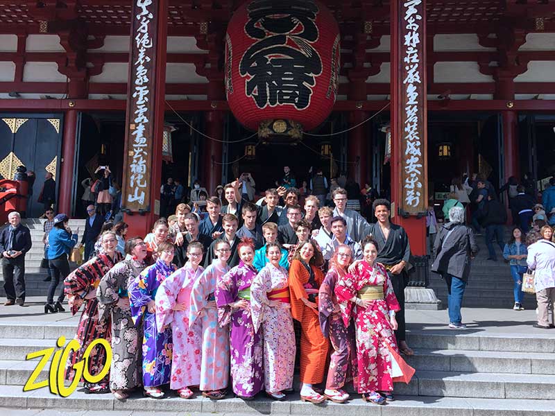 des jeunes en tenues traditionnelles devant un temple