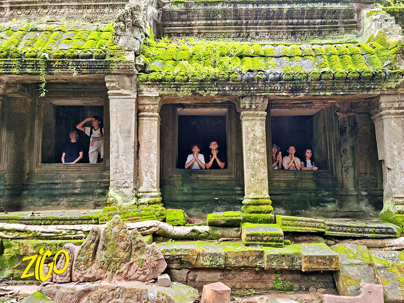 Participants framed in the windows of an Angkor temple