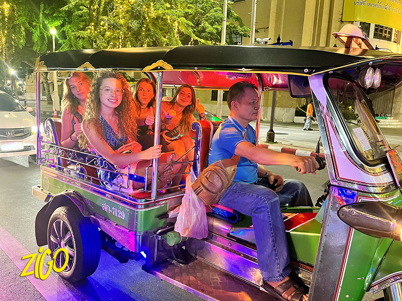 Riding through the city at night by tuk-tuk