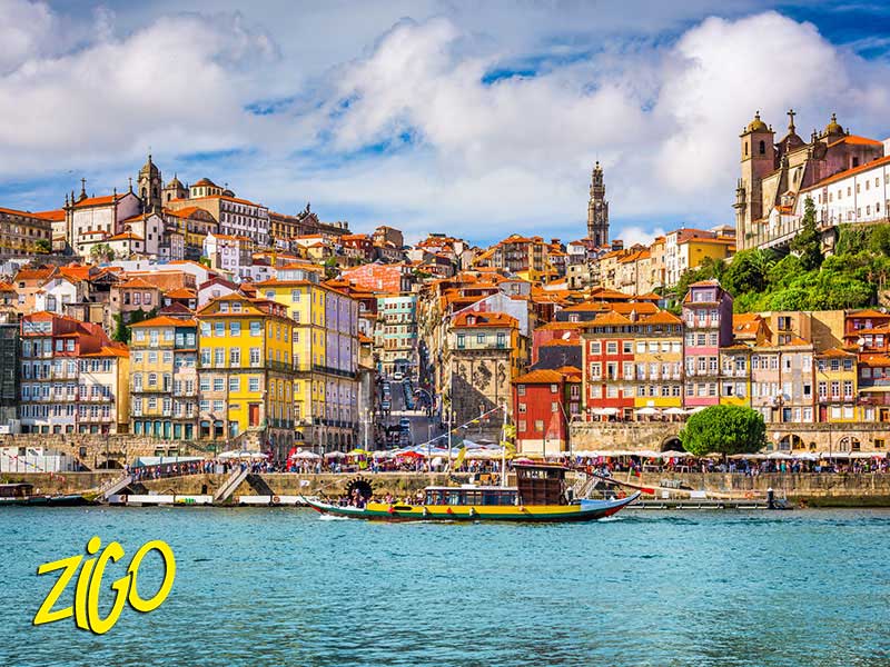 Coloured houses of the Ribeira district stacked above the Douro, boats moored along the quay