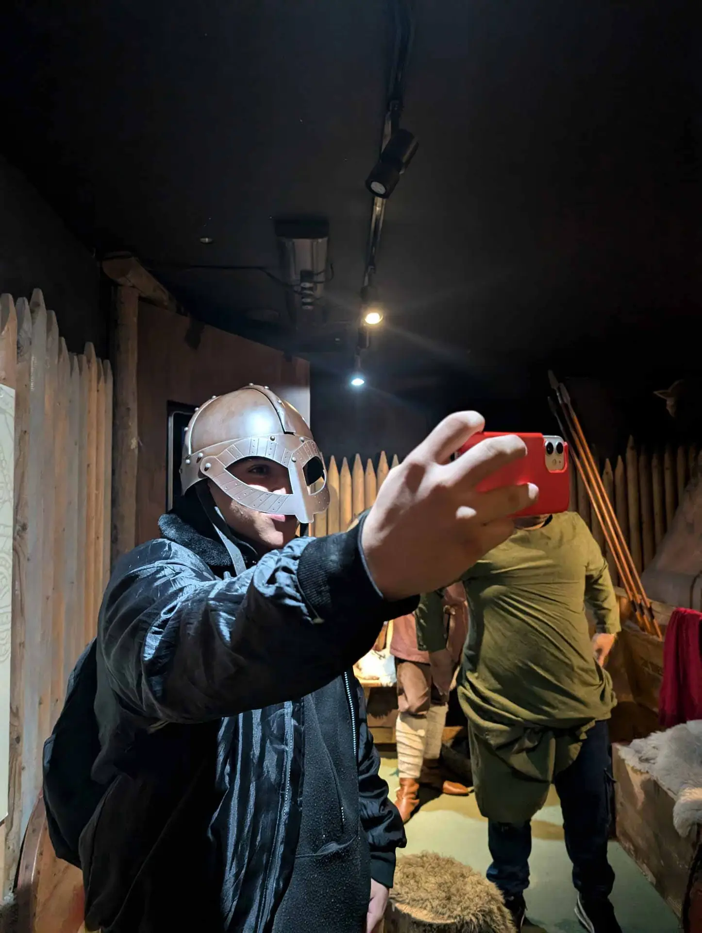 A young adult student trying on a Viking helmet and taking a photograph during a Dublin cultural visit
