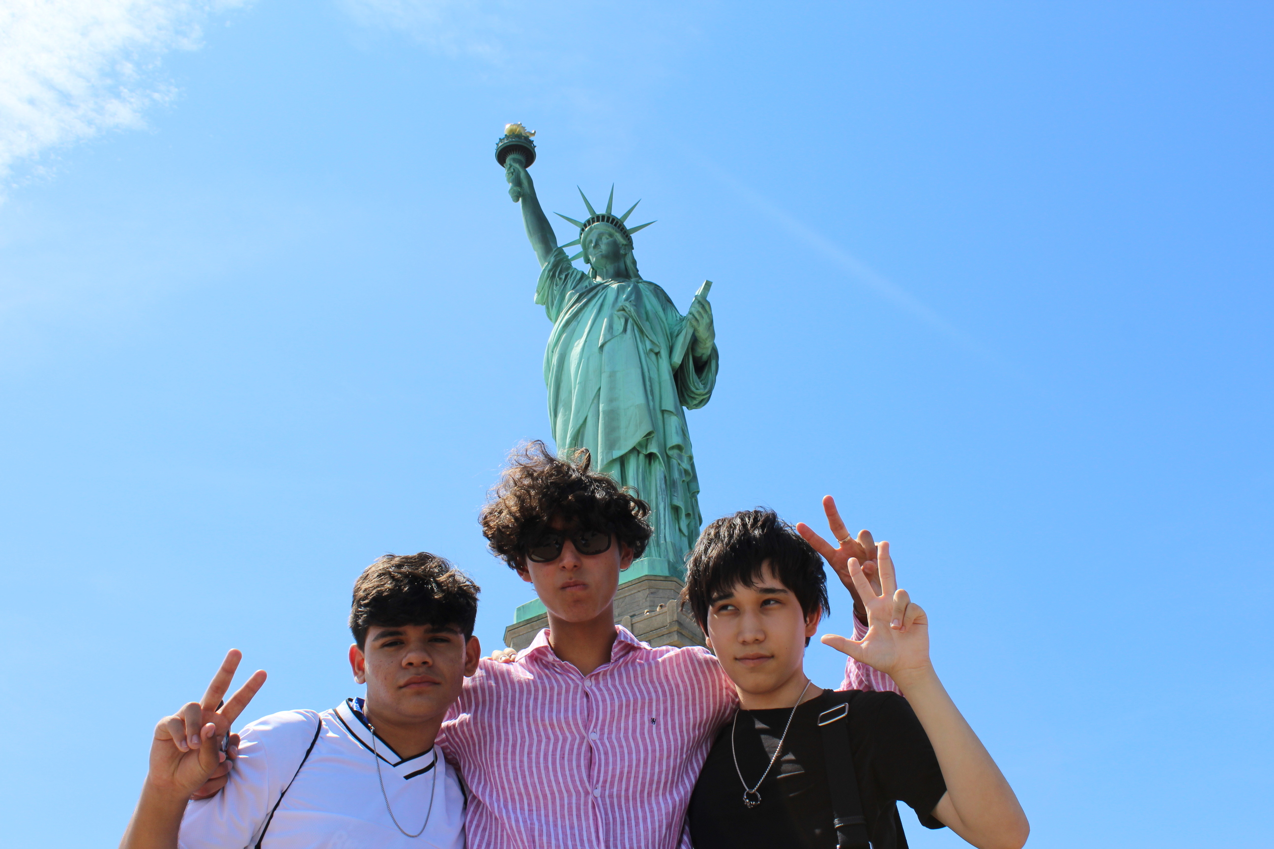 Teenage campers posing in front of the Statue of Liberty during a New York excursion